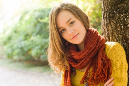 Closeup portrait of a fashionable young blond outdoors in the park on sunny autumn day.の写真素材
