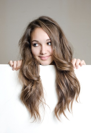 Portrait of a cute young brunette teen with white banner, showing off long hair.の写真素材