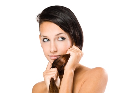 Closeup portrait of gorgeous young brunette woman showing of her shiny healthy hair.の写真素材