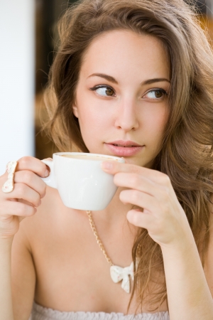 Portrait of a romantic looking hot coffee brunette lady.の写真素材