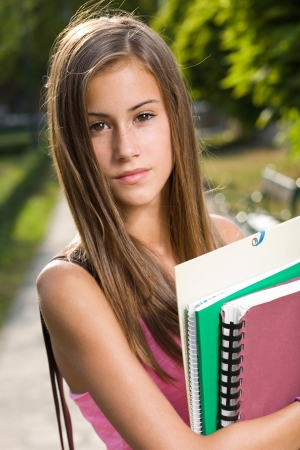 Outdoors portrait of a beautiful tanned teen student girl.の写真素材
