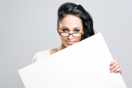 Portrait of an attractive young brunette with blank white sign.の写真素材