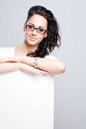 Portrait of a gorgeous young brunette woman with blank billboard.の写真素材