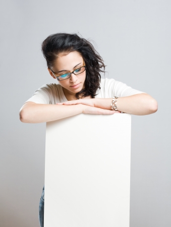 Portrait of an attractive young brunette with blank white sign.の写真素材