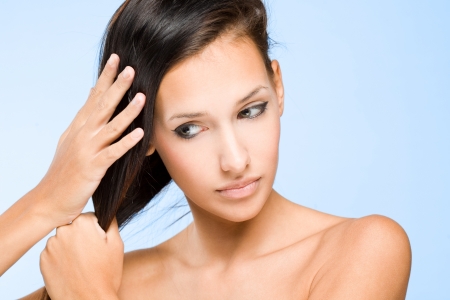 The hair check, portrait of a beautiful young brunette woman with shiny hair.の写真素材