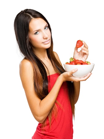 Portrait of a young brunette beauty with a bowl of fresh strawberries.の写真素材