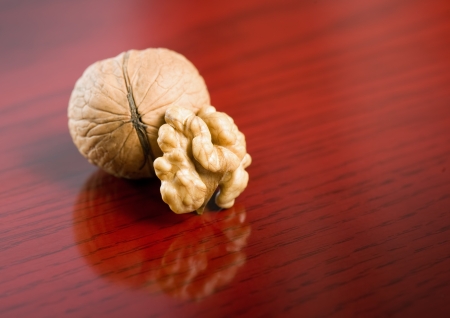 Closeup shot of tasty healthy walnut on dark red wood background.の写真素材