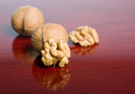 Closeup shot of tasty healthy walnut on dark red wood background.の写真素材