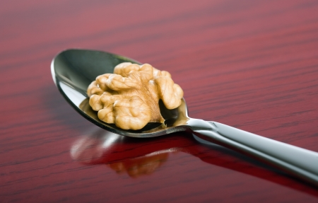 Closeup shot of tasty healthy walnut on dark red wood background.の写真素材