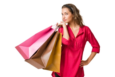 Gorgeous young brunette woman holding colorful shopping bags isolated on white background.の写真素材