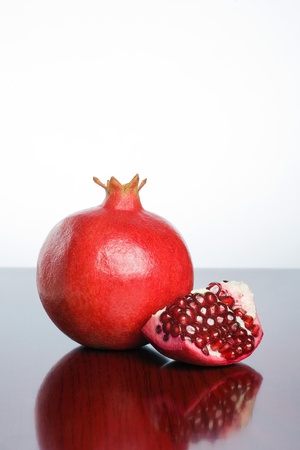 Studio shot of fresh ripe pomegranate whole and part with seeds.の写真素材