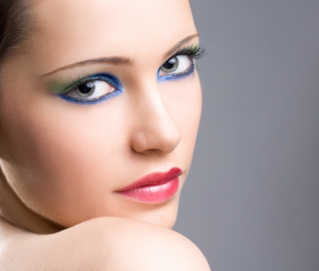 Portrait of a dramatic colorful makeup girl on gray background.の写真素材