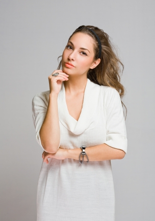 Studio portrait of friendly pensive young brunette beauty の写真素材