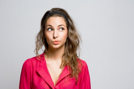 Portrait of doubtful looking beautiful young brunette の写真素材