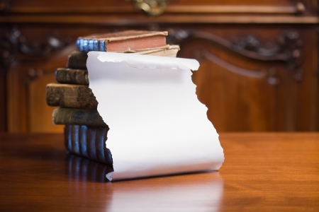 Pile of antique books with blank white scroll for copy space.の写真素材