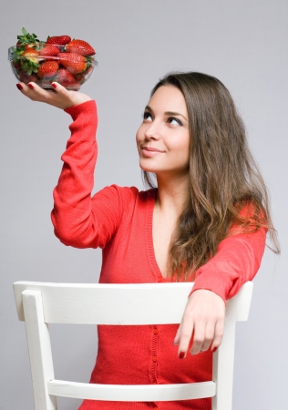 Gorgeous friendly young brunette woman with juicy strawberries の写真素材