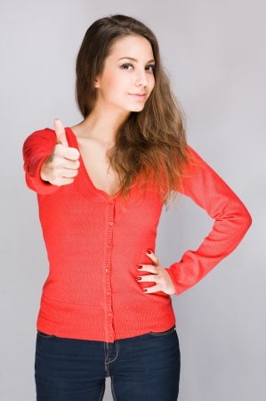Portrait of proud looking young brunette showing thumbs up の写真素材
