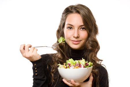 Cute young brunette woman eating fresh green salad.の写真素材