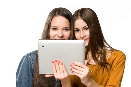 Two fashionable young teenagers having fun with a tablet computer.の写真素材