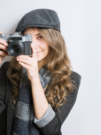 Portrait of very fashionable young brunette with retro film camera の写真素材