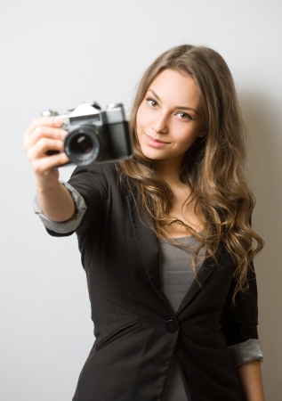 Portrait of a cute young brunette photographer with her camera の写真素材