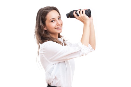 Portrait of brunette beauty holding binoculars isolated on white background.の写真素材
