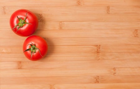 Ripe fresh tasty tomatoes on a wooden cutting board, with copy space.の写真素材