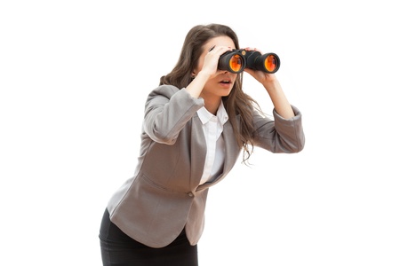 Portrait of surprised looking young office girl with binoculars.の写真素材