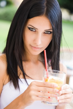 Portrait of gorgeous brunette woman drinking some summer refreshment.の写真素材