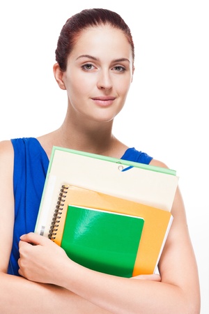 Cute young redhead student holding colorful exercise books.の写真素材