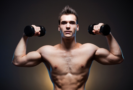 Dark moody portrait of very fit ripped young athlete.の写真素材