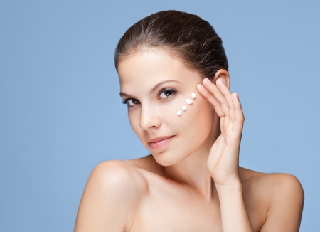 Portrait of a beautiful young brunette using lotion.の写真素材