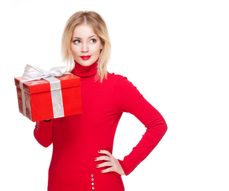Portrait of a beautiful young blond woman holding shiny red gift box.の写真素材