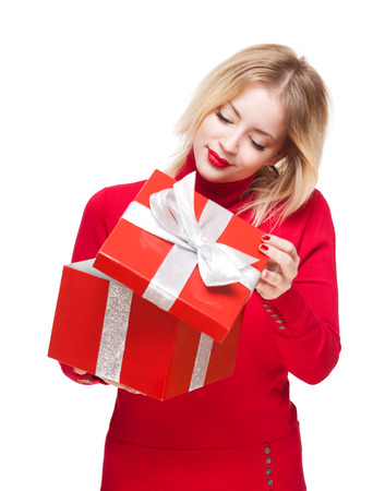 Portrait of a beautiful young blond woman holding shiny red gift box.の写真素材