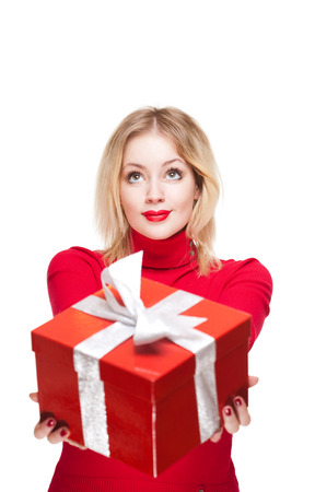 Portrait of a beautiful young blond woman holding shiny red gift box.の写真素材