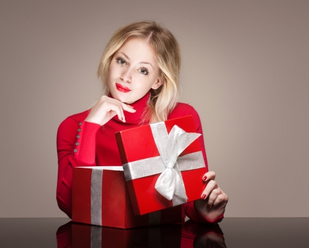 Portrait of a cute young blond with bright red gift box.の写真素材