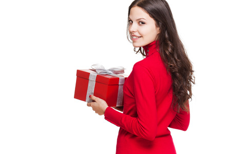 Portrait of a gorgeous young brunette woman with bright red gift box.の写真素材