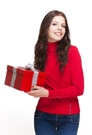 Portrait of a gorgeous young brunette woman with bright red gift box.の写真素材