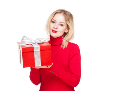 Cute young blond woman holding shiny red gift box.の写真素材