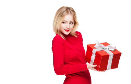 Cute young blond woman holding shiny red gift box.の写真素材