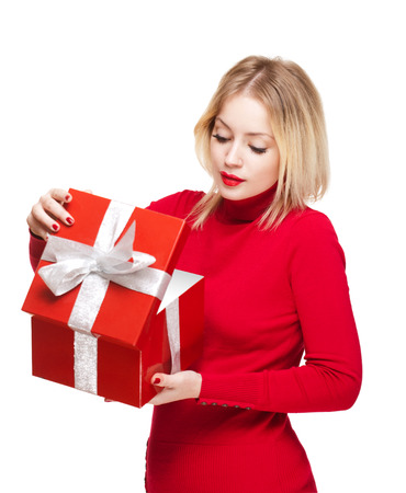 Cute young blond woman holding shiny red gift box.の写真素材