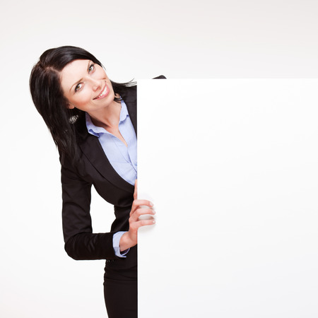 Gorgeous young smiling businesswoman holding blank banner.の写真素材