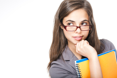 Portrait of a beautiful young brunette student on white background.の写真素材