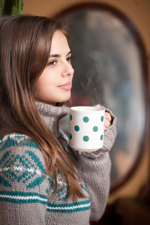 Portrait of a gorgeous brunette enjoying a cup of hot brunette.の写真素材