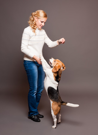 Portrait of a beautiful young blond woman with a cute beagle.の写真素材