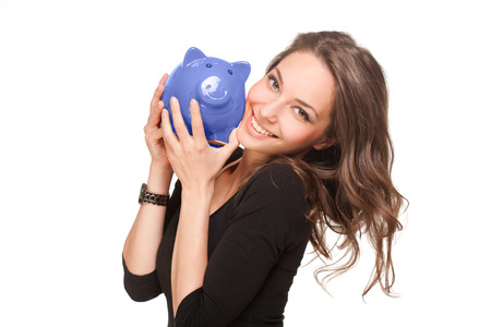 Portrait of a gorgeous young brunette woman with shiny piggy bank.の写真素材