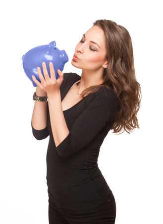 Portrait of a gorgeous young brunette holding piggy bank isolated on white background.の写真素材