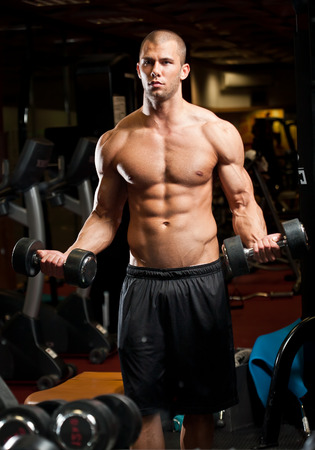 Portrait of an attractive athletic young man in a gym.の写真素材