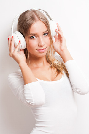 Portrait of a gorgeous young blond woman wearing headphones.の写真素材