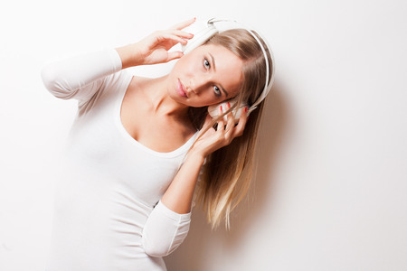 Portrait of a gorgeous young blond woman wearing headphones.の写真素材